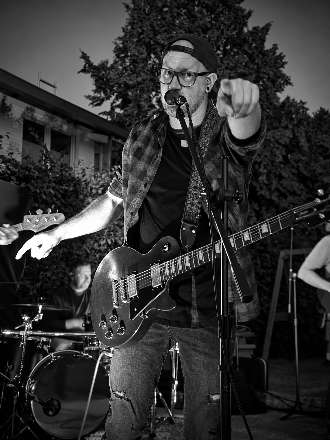 Benny mit Gitarre und Gesangsmikrofon beim Live-Auftritt